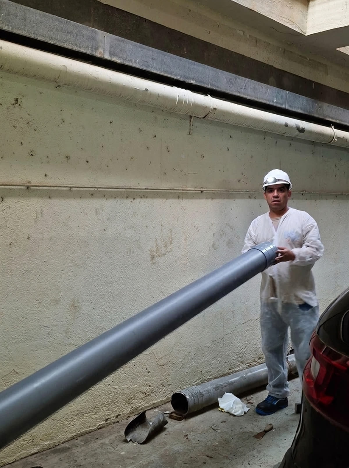 Operario de MUTODESA colocando un tubo nuevo de PVC en el sótano de un edificio